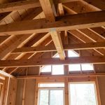Inspection visuelle de la charpente en bois dans une maison, ambiance préventive, lumière naturelle, sans présence humaine.