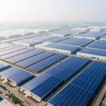 Vue aérienne réaliste d’une vaste usine de panneaux solaires en Chine, avec des bâtiments industriels modernes et de nombreux panneaux photovoltaïques bleus éclairés par la lumière du matin.